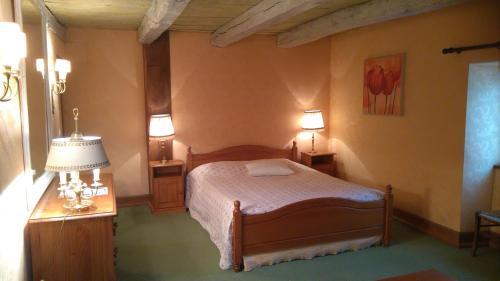 a bedroom with a bed and a table and lamps at Les Vergnes in Saint-Pardoux-le-Neuf