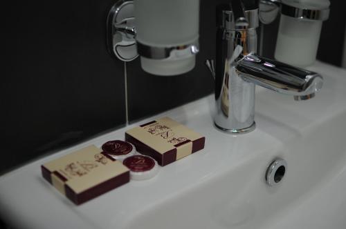 a white sink with two pieces of chocolate on it at Millenium Palace in Ohrid
