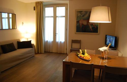 a living room with a couch and a table with a bowl of fruit at Ceccarini Suite in Riccione