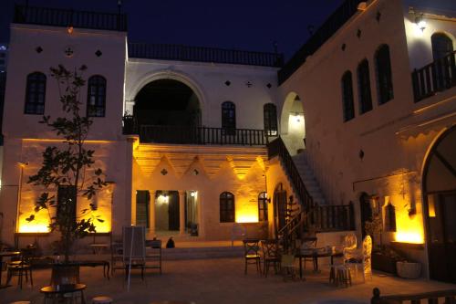 a large building with tables and chairs at night at Kasr-ı Canan in Halfeti