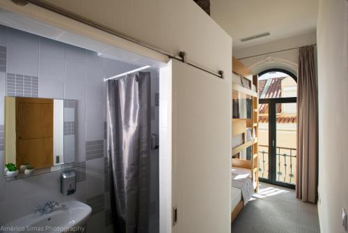 y baño con ducha y lavamanos. en Day Off Suite&Hostel en Setúbal