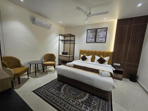 a bedroom with a bed and a table and chairs at HOTEL AYUSHMAN in Varanasi