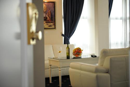 a living room with a chair and a table with a bottle of wine at Millenium Palace in Ohrid