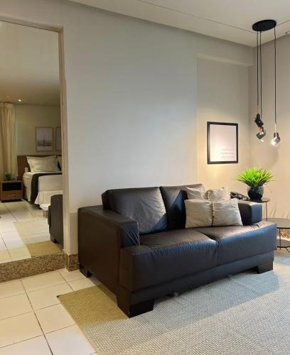 a living room with a couch and a bedroom at St Oeste Superking Ar, Cozinha, Office, Vaga in Goiânia