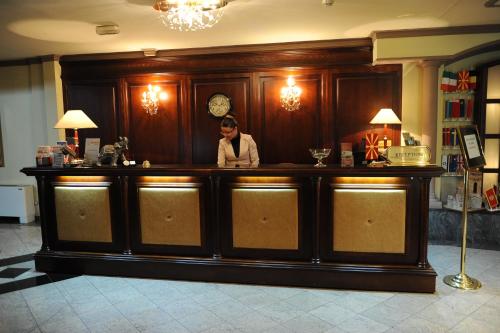 a woman standing behind a bar in a restaurant at Millenium Palace in Ohrid
