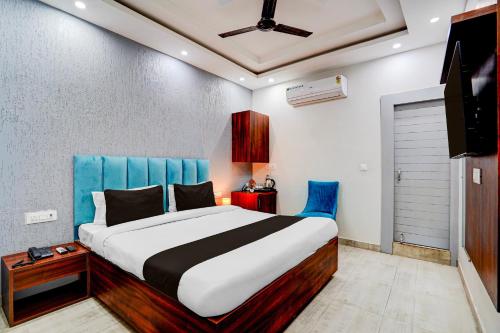 a bedroom with a large bed with a blue headboard at Collection O Kotdwar Railway Junction Formerly K Square in Kotdwāra