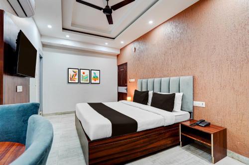 a bedroom with a bed and a blue chair at Collection O Kotdwar Railway Junction Formerly K Square in Kotdwāra