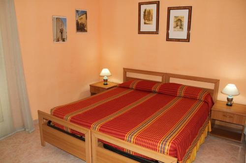 una camera con un letto con due comodini e due lampade di Garden House a Pozzallo