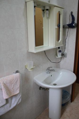 a bathroom with a white sink and a mirror at Garden House in Pozzallo