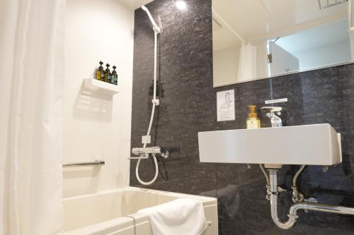 a bathroom with a tub and a sink and a shower at RJ HOTELS OTARU in Otaru