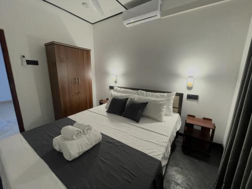 a bedroom with a bed with two towels on it at Thousand Sunny Villa in Duwegoda
