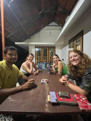 a group of people sitting around a wooden table at FREEDOM HOUSE, Munroe Island , Kollam - A Backpackers Hostel in Munroe Island