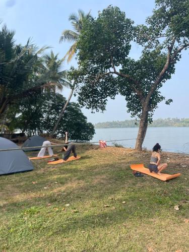 a group of people sitting on surfboards on the grass at FREEDOM HOUSE, Munroe Island , Kollam - A Backpackers Hostel in Munroe Island