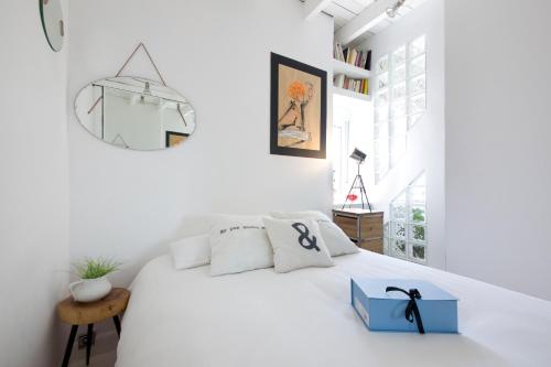 a white bedroom with a white bed with a blue box on it at Merlot Apartment in San Sebastián