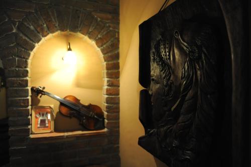 a violin in a room with a brick wall at Millenium Palace in Ohrid