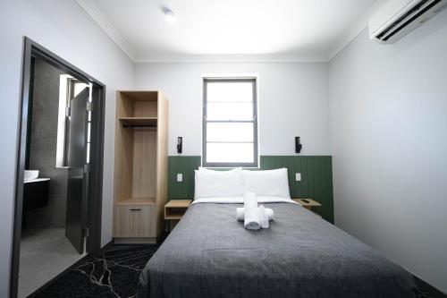 a bedroom with a bed with a teddy bear on it at Belmore Hotel Maitland in Maitland