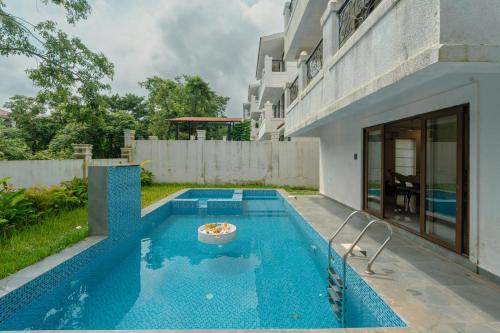 a swimming pool in the backyard of a house at ELIVAAS Signature Casa Verdea 4-BHK Villa With Private Pool & Lift Near Popular Restaurants in Siolim