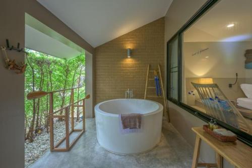 a large bathroom with a large tub and a balcony at Deevana Krabi Resort in Ao Nang Beach