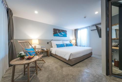 a bedroom with a bed and a table and a chair at Deevana Krabi Resort in Ao Nang Beach