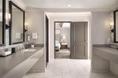a bathroom with two sinks and a bedroom at Grand Hyatt Atlanta in Buckhead in Atlanta