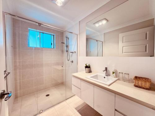 a white bathroom with a shower and a sink at A Zen Tea Sanctuary in Australia in Schofields