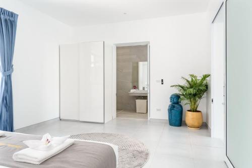 a white room with a bed and a bathroom at Buddha Bliss Luxury Villa in Ban Madua Wan