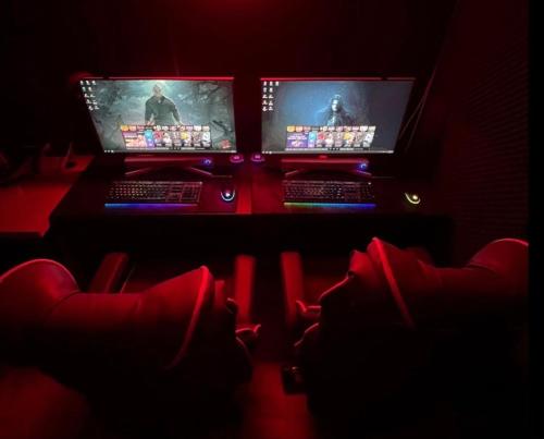 two computer monitors sitting on a desk in a dark room at 달빛소리호텔 in Ajung-yŏk