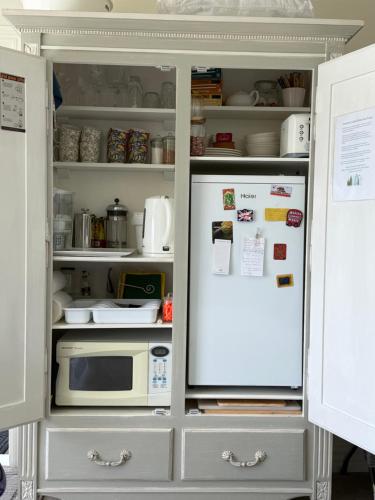 an open refrigerator with a microwave in it at Incredible Views! Luxurious Studio & Outdoor Living in Wellington