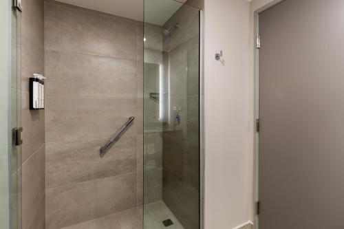 a shower with a glass door in a bathroom at Hyatt Place Merida/ Via Montejo in Mérida