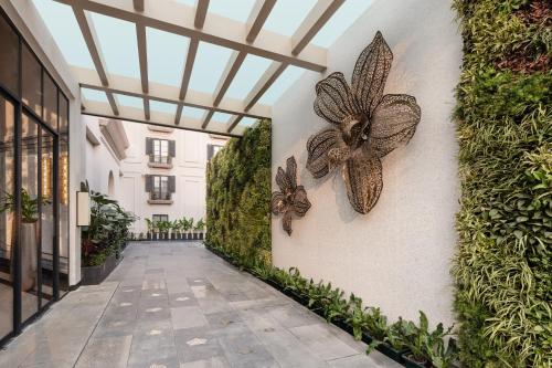 a walkway with butterflies on the wall of a building at Renaissance Goa Hotel in Goa