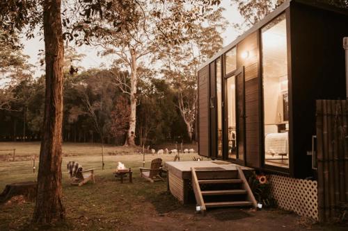 a house with a large window and a tree at The Stables by Tiny Away in Palmwoods