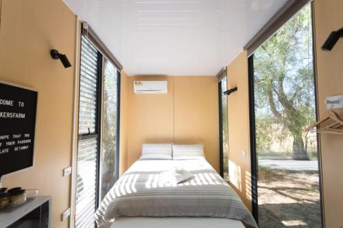 a bed in a room with a large window at Organic Farm Stay by Tiny Away in Numurkah