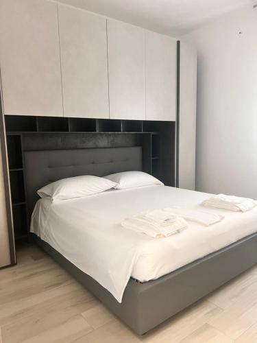 a white bed with a black headboard and white pillows at Dimora Patio in Policoro