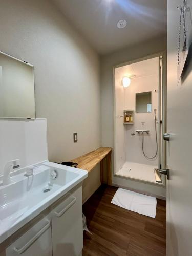 ein Badezimmer mit weißem Waschbecken und Dusche in der Unterkunft Lodges大黒 in Toyama
