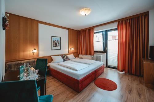 a hotel room with a bed and a table at Apart-Pension Oberreiter in Fusch an der Glocknerstraße