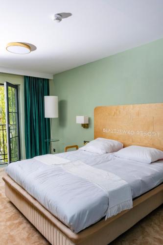 a bedroom with a large bed with white sheets at Błażejewko Resort in Błażejewko
