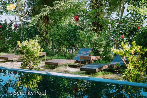 a group of benches in a garden next to a pool at TV Palm Ecolodge Ha Giang in Ha Giang