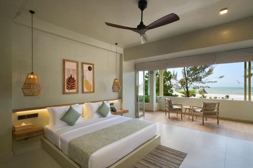 a bedroom with a bed and a view of the ocean at Stay Ceylon - Weligama in Weligama