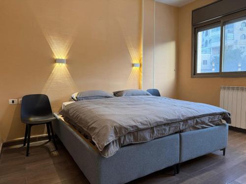 a bedroom with a bed with two chairs and a window at Har nof rooftop in Jerusalem