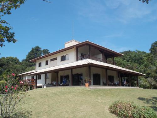a large house on top of a grass field at Haute Haus - Guest House in Florianópolis