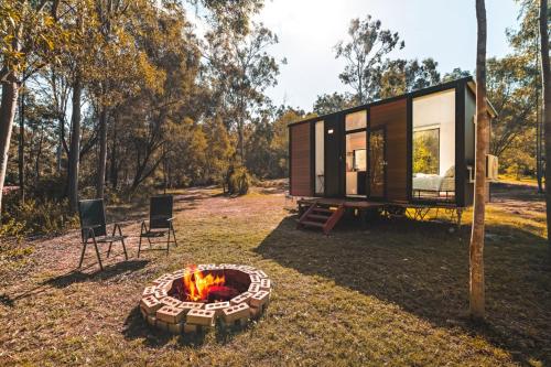 a tiny house with a fire pit in the yard at Mirror Reflections by Tiny Away in Tamborine
