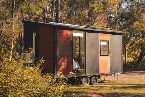 a tiny house on a trailer in a field at Mirror Reflections by Tiny Away in Tamborine