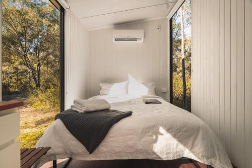 a bedroom with a bed and a large window at Mirror Reflections by Tiny Away in Tamborine