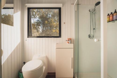 a small bathroom with a toilet and a window at Mirror Reflections by Tiny Away in Tamborine