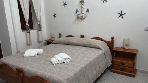 a bedroom with a bed with towels on it at Domo via Ozieri in Iglesias