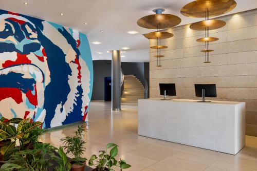 a lobby with a reception desk and a painting on the wall at Vienna House by Wyndham Andel's Cracow in Krakow