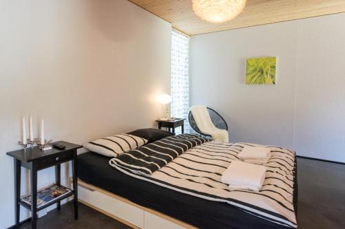 1 dormitorio con 1 cama con almohadas a rayas en Il Cubo, en Berna