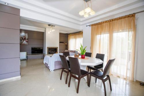 a dining room and living room with a table and chairs at Seascape Village - Spacious 3-Bed Apartment with Private Garden and Parking in Kalithies