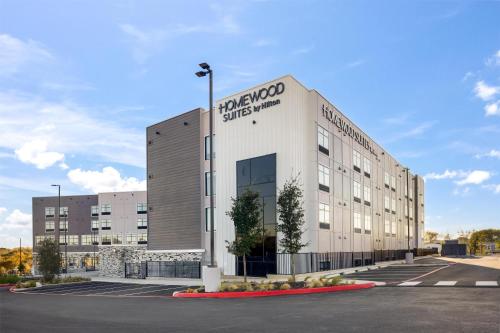 a large white building with a sign on it at Homewood Suites By Hilton Austin Airport in Austin