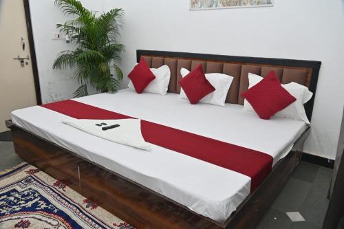 a bed with red and white pillows on it at pitambara studio apartment with kitchen in Karadoho